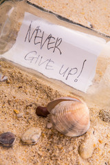 Concept image of a message NEVER GIVE UP in a bottle