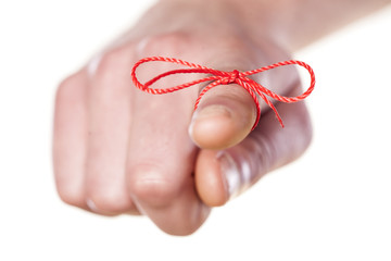 man's finger bound with red thread
