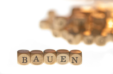 Wort "Bauen" aus Buchstabenwürfeln, freigestellt, Freisteller