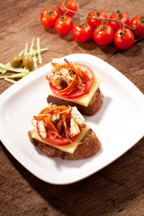 bread seasoned with oil and sliced tomatoes on a table