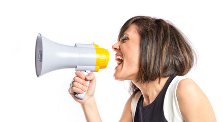 Naklejka premium Pretty girl shouting with a megaphone over white background