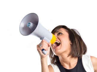 Pretty girl shouting with a megaphone over white background