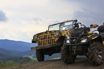 Obraz premium Dirty SUV and the vehicle on top of the mountain.