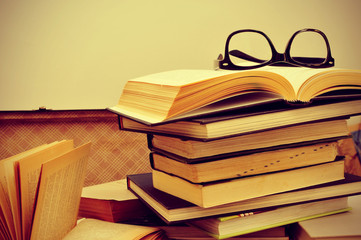 books and eyeglasses in an old suitcase, with a retro effect