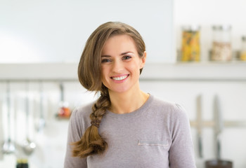 Portrait of happy young woman in modern kitchen