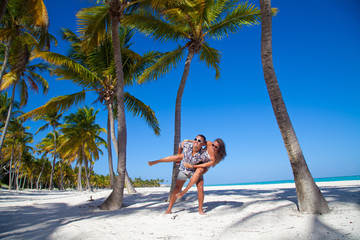Man giving piggyback ride to girlfriend at the Caribbean beach