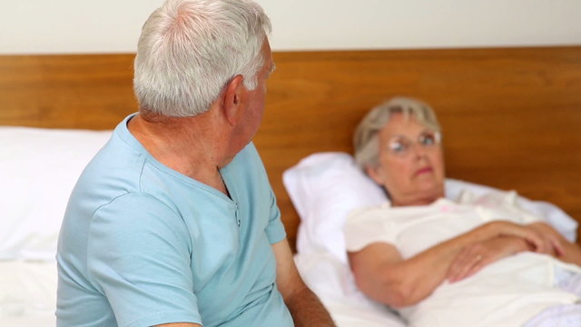 Senior couple not speaking after an argument on bed