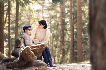 Fototapeta premium Mother and her little son sitting on a bench