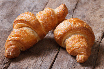 two croissants on an old wooden table closeup