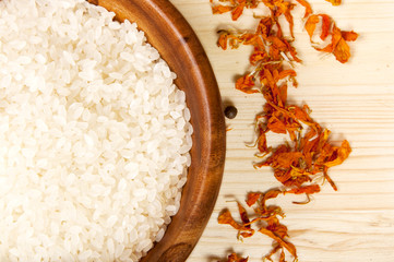 spices and rice in wooden bowl on  a wooden table background