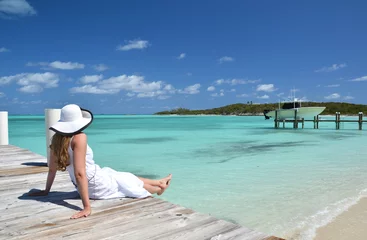 Foto op Plexiglas Girl on the wooden jetty looking to the ocean. Exuma, Bahamas © HappyAlex
