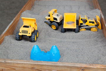 Toys in a Wooden Sandbox.