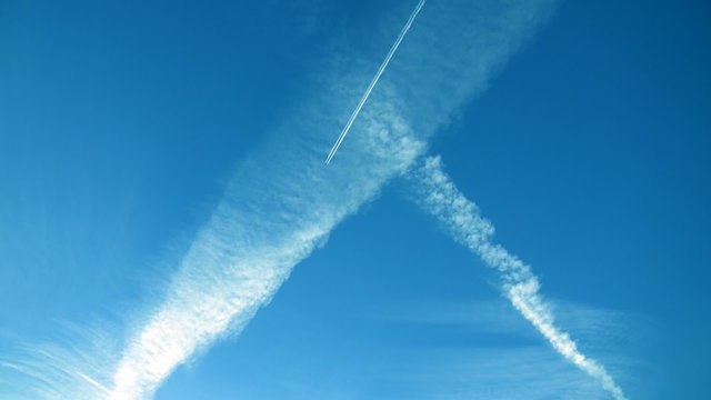 Airplane crossing blue sky