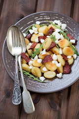 Glass plate with roasted gnocchi, meat and cheese, above view