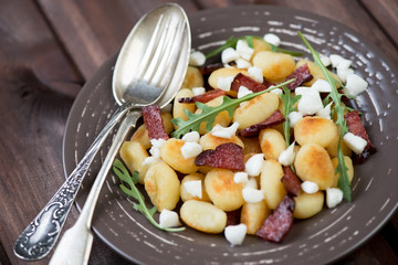 Fried gnocchi with meat, cheese and arugula, horizontal shot
