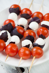 Kebabs with mozzarella, cherry tomatoes and purple basil