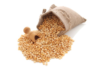 yellow split peas in a burlap bag with an wood scoop