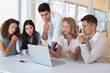 Obraz premium Casual business team having a meeting using laptop
