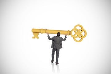 Composite image of businessman carrying large key