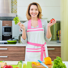 Happy young woman cooking a salad.