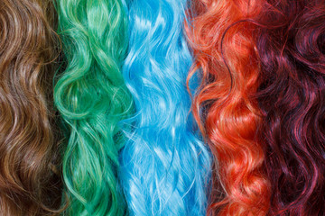 Coloured wigs with long wavy fake hair - obrazy, fototapety, plakaty