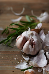 Peeled Garlic Bulb, Rosemary and Salt on a Kitchen Table