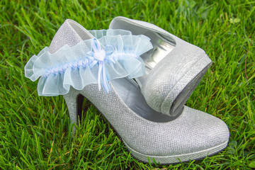 Light blue lace garter arranged with silver high heel shoes