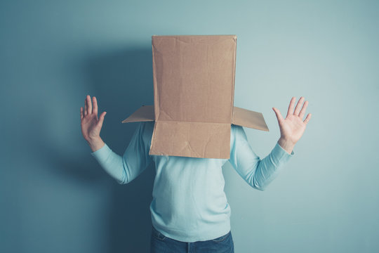 Shocked man with cardboard box on his head
