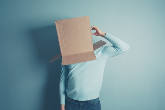 Confused man with cardboard box on his head