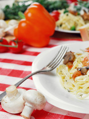 Pasta with shrimps and mashrooms on the wooden table
