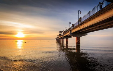 Selbstklebende Fototapete Seebrücke Sonnenuntergang und Pier in Miedzyzdroje
