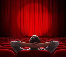 man sitting alone in  empty theater or cinema hall © Andrey Kuzmin