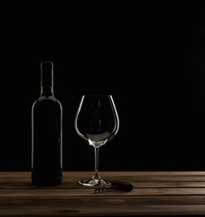 Bottle,glass and corkscrew on a wooden table