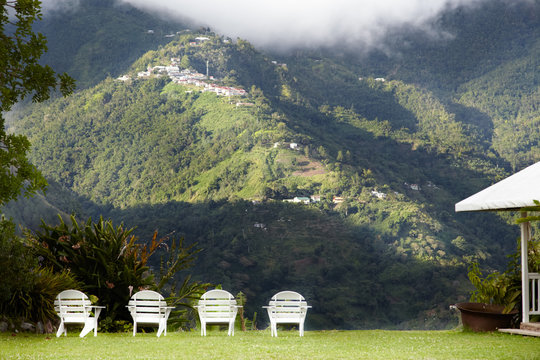 Chairs in a garden with mountain in the background, Jamaica