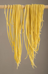 homemade spaghetti hung on a wooden stick