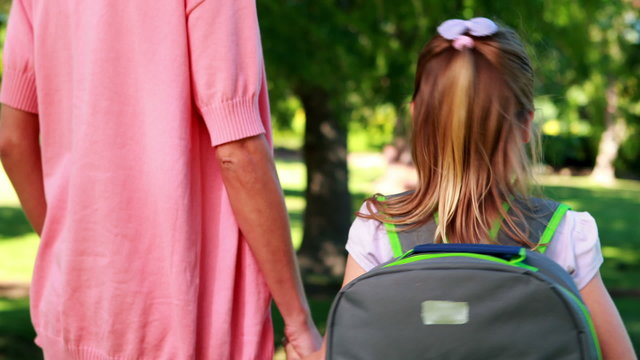 Mother waiting with her smiling daughter on the first day of sch