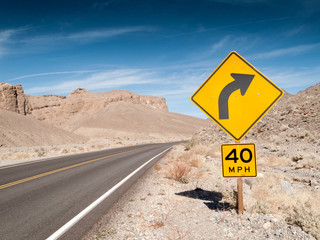 Road sign with empty road, Death Valley National Park, Californi