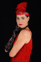 Young beautiful brunette in 1920 style attire red dress and a fe