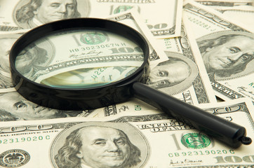 Magnifying glass and money - business background