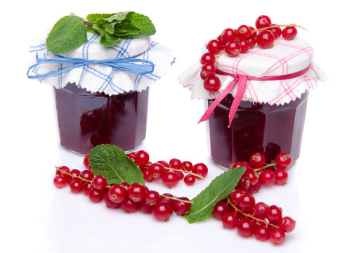 Two jars of redcurrant jam with fresh redcurrants and mint