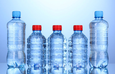 plastic bottles of water on blue background