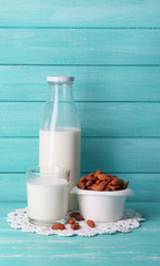 Almond milk in bottle with almonds in bowl,