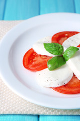 Caprese salad with mozarella cheese, tomatoes and basil