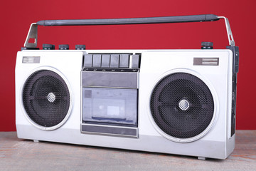 Retro cassette stereo recorder on table on red background