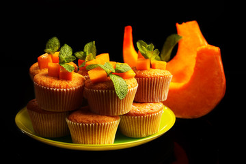Tasty pumpkin muffins on dark background