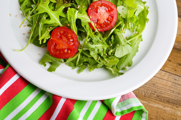 Green salad made with  arugula, tomatoes and sesame