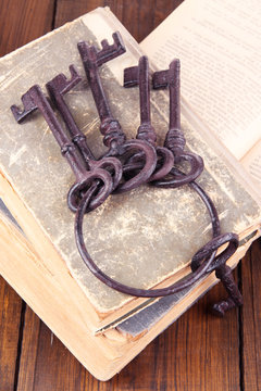 Old keys on old books on wooden background