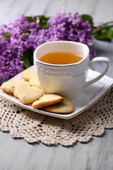 Obraz na płótnie Canvas Lavender cookies and cup of tasty tea on color wooden