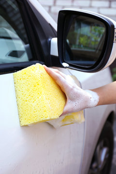 Outdoor car wash with yellow sponge