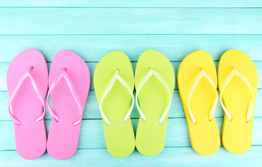Bright flip-flops on color wooden background